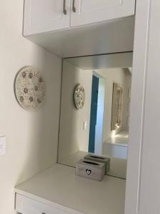 a white bathroom with a mirror and a sink at Gorgeous, private cottage in prestigious Newlands. in Cape Town