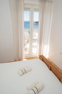 a bedroom with a bed with a view of the ocean at Apartments and rooms LJUBICA in Lun
