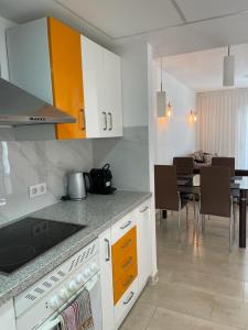 uma cozinha com armários brancos e uma sala de jantar em Apartamento en La Calma em Playas de Orihuela