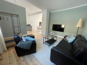 ein Wohnzimmer mit 2 Sofas und einem Flachbild-TV in der Unterkunft Lägenhet Söder om Landsvägen C in Skivarp
