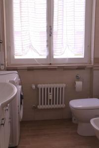 baño con aseo, ventana y radiador en Cinque Terre Boito Apartament, en La Spezia