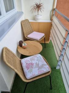 einen Balkon mit 2 Stühlen, einem Tisch und Stühlen in der Unterkunft Apartman Centar in Kraljevo