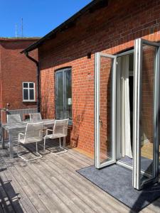 eine offene Terrasse mit einem Tisch und Stühlen auf einer Terrasse in der Unterkunft Lägenhet Söder om Landsvägen C in Skivarp