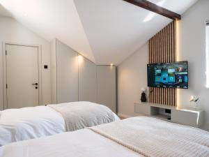 a bedroom with two beds and a flat screen tv at Residence Republic Square- Top Location in Belgrade