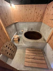 La salle de bains est pourvue d'une grande baignoire et de toilettes. dans l'établissement 能登ごはん農場 暮らしの宿じろざみ, à Nanao