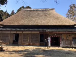 un bâtiment avec un toit de paille avec un portail dans l'établissement 能登ごはん農場 暮らしの宿じろざみ, à Nanao