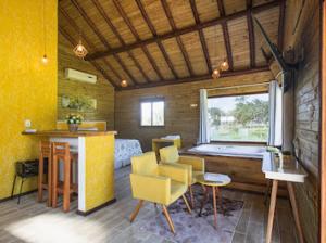 een woonkamer met een tafel en stoelen en een raam bij Pousada Canyons do Sul in Praia Grande