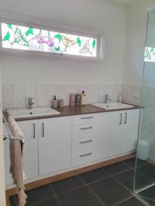 a bathroom with two sinks and a window at Set amongst the treetops of Arthurs Seat in Arthurs Seat