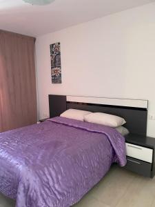 プレヤス・デ・オリフエラにあるApartamento en La Calmaの- ベッドルーム内のベッド(紫色の掛け布団付)