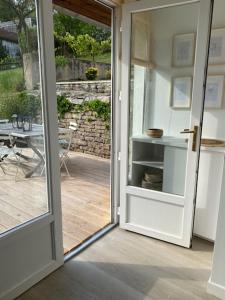 een open deur naar een patio met een tafel bij Le nid des mésanges in Buffon