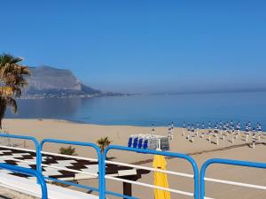 una playa con un montón de sillas y el océano en La Dependance delle Mimose en Isola delle Femmine