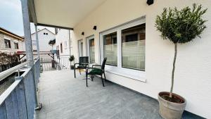 a balcony with a chair and a table and a plant at Heimatliebe Erfweiler Wohnung ZWÄ in Erfweiler