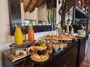 a buffet with many plates of food and drinks at Karongwe Portfolio - Kuname Lodge in Hoedspruit