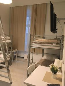 Dormitorio con letti a castello e TV di CH-Hostel a Vienna