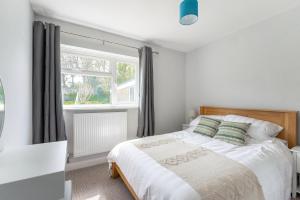 a bedroom with a bed and a window at Quiet Cotswold Bungalow in Charlbury