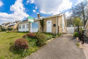 a house with a driveway in front of it at Quiet Cotswold Bungalow in Charlbury