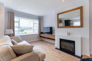 a living room with a couch and a mirror at Quiet Cotswold Bungalow in Charlbury
