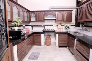 una cocina con armarios de madera y un jarrón en el suelo en Fortune Home Service Apartment,2Bhk, D-198,SAKET en Nueva Delhi