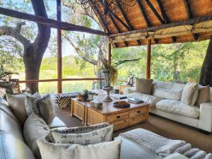 uma sala de estar com sofás brancos e uma mesa em Karongwe Portfolio - Kuname Lodge em Karongwe Game Reserve