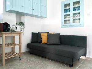 a couch in the corner of a room at Black Pebble Myconian House in Ano Mera