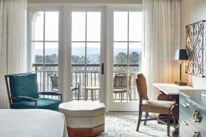 a hotel room with a bed and a desk and chairs at Renaissance Birmingham Ross Bridge Golf Resort & Spa in Hoover