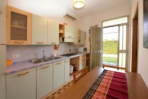 uma cozinha com armários brancos e uma grande janela em GREEN HOUSE em Cavallino-Treporti