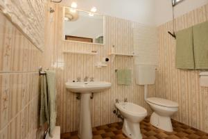 y baño con lavabo, aseo y espejo. en GREEN HOUSE en Cavallino-Treporti