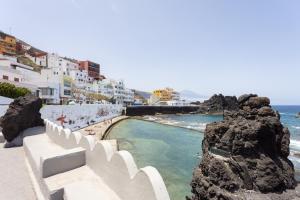 vistas a una playa con edificios blancos y al océano en La Fula Beach Rooms, en El Pris