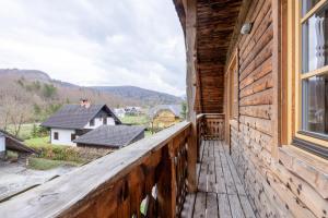 Un balcón de una casa de madera con ventana en Apartments Brina en Bohinj