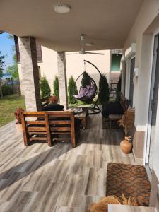 a porch with a bench and a hammock on a house at Koreni Celarevo in Čelarevo