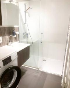 y baño con lavadora y ducha. en Appartement au Centre Ville, en Bruselas