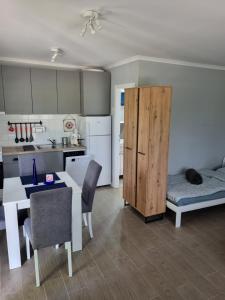 uma sala de estar com uma mesa e uma cozinha em Apartman 27 Palic em Palić