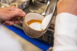 a person is holding a cup of coffee at Palazzo Rivola in Bergamo