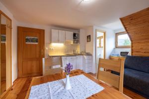 a kitchen and living room with a vase of flowers on a table at Apartments Brina in Bohinj