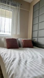 Elle comprend un grand lit avec deux oreillers et une fenêtre. dans l'établissement Apartament Presto 17 by Housine, à Zator