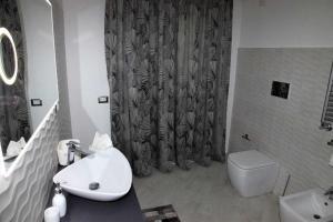 ein Bad mit einem Waschbecken, einem WC und einer Dusche in der Unterkunft Vampolieri luxury home in Aci Catena