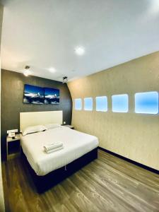 1 dormitorio con 1 cama blanca grande y algunas ventanas en Sri Langit Hotel KLIA, KLIA 2 & F1, en Sepang