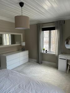 1 dormitorio con cama blanca y espejo en Sandstad, Lilleby i Trondheim, en Trondheim
