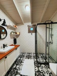 a bathroom with a shower with a black and white floor at Egeos Lake House in Sakarya