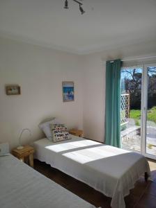 um quarto com 2 camas e uma janela em Villa Olivaie St Ange em La Gaude