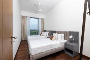 a hotel room with two beds and a window at Twin Peaks residence in Colombo +13 photos