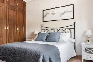 a bedroom with a black and white bed with blue pillows at Unifamiliar Europa in Ciudad Real