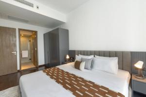 1 dormitorio con 1 cama blanca grande y 2 lámparas en Twin Peaks residence, en Colombo