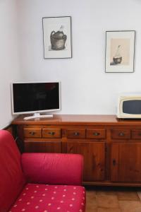 ein Wohnzimmer mit einem roten Stuhl und einem TV in der Unterkunft Casa Celestino in Trarego Viggiona
