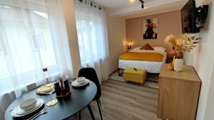 Zimmer mit einem Bett, einem Esstisch und einem Bett in der Unterkunft ELApart by Homely Stay - Moderne Apartments mit Self-Check-in in Bad Kissingen