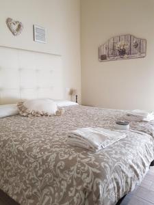 a white bedroom with a bed with a blanket at Luna City in Ravenna