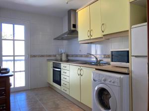 a kitchen with a washing machine and a washer at Las Rocas Golf and Sea in Caleta De Fuste