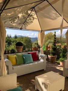 a white couch with colorful pillows on a patio at Hotel La Capannina in Aritzo