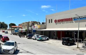 a street with cars parked in front of a building at Golden days in Afantou