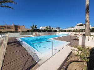 a swimming pool in a resort with a palm tree at Stunning Apartment La Cala de Mijas - Walking Distance to the Beach and Town - Pool Open in La Cala de Mijas
